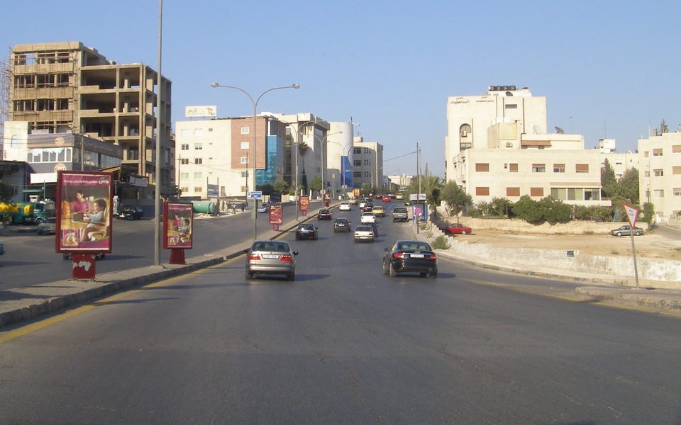 شارع واسع في الشميساني، عمّان، تحيط به مبانٍ متعددة الطوابق ولوحات إعلانية (2008)